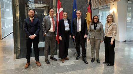 Ministerpräsident Daniel Günther steht gemeinsam mit den Vertreterinnen und Vertreterinnen der skandinavischen Staaten im Foyer der dänischen Botschaft